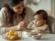 Indian mother feeding 7 month old baby khichdi in a high chair at home