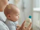Parent applying lotion to baby with seborrheic dermatitis cradle cap on scalp